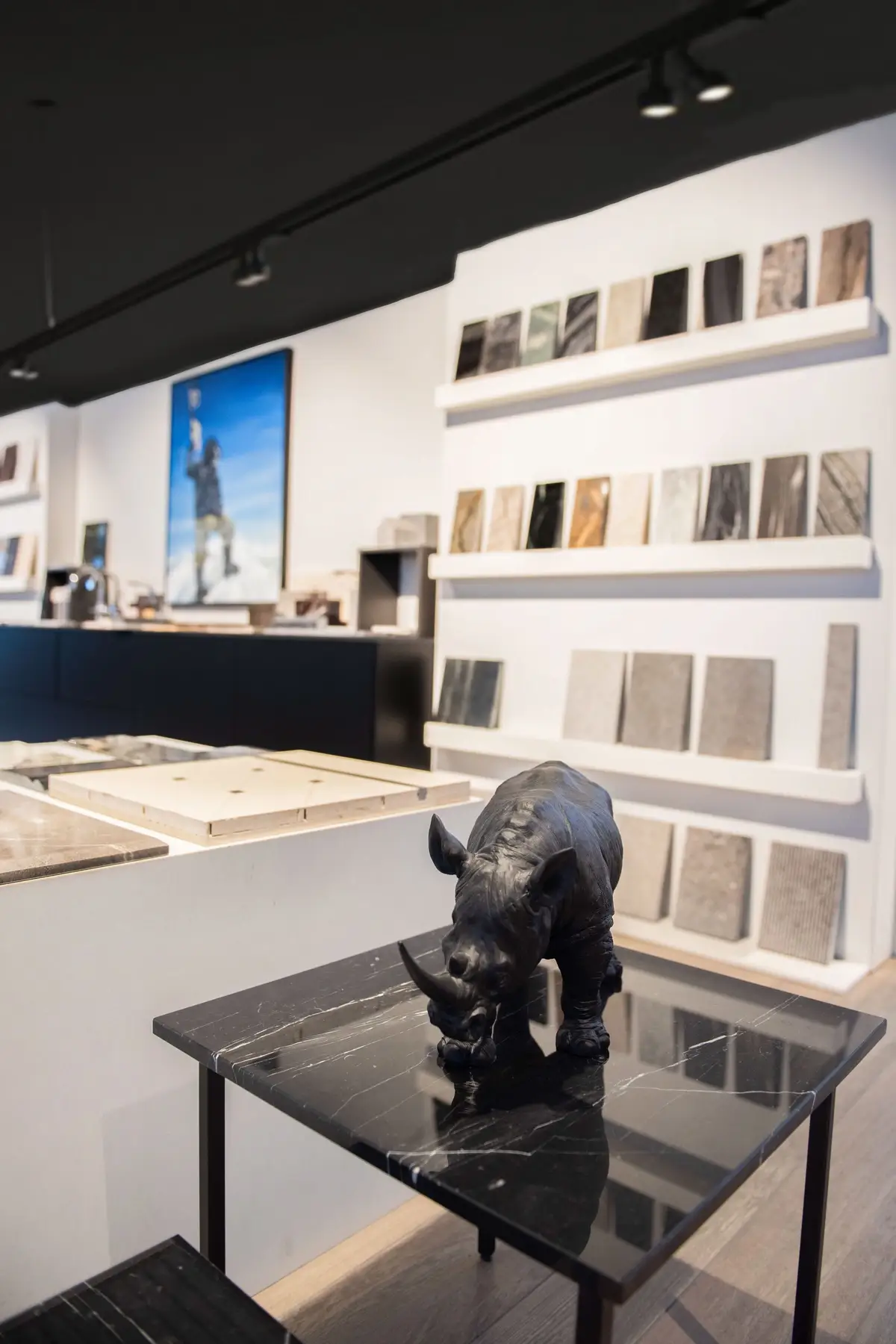 Showroom-Szene mit Nashornfigur auf Naturstein-Beistelltisch – stilvolle Inszenierung von Material und Objekt
