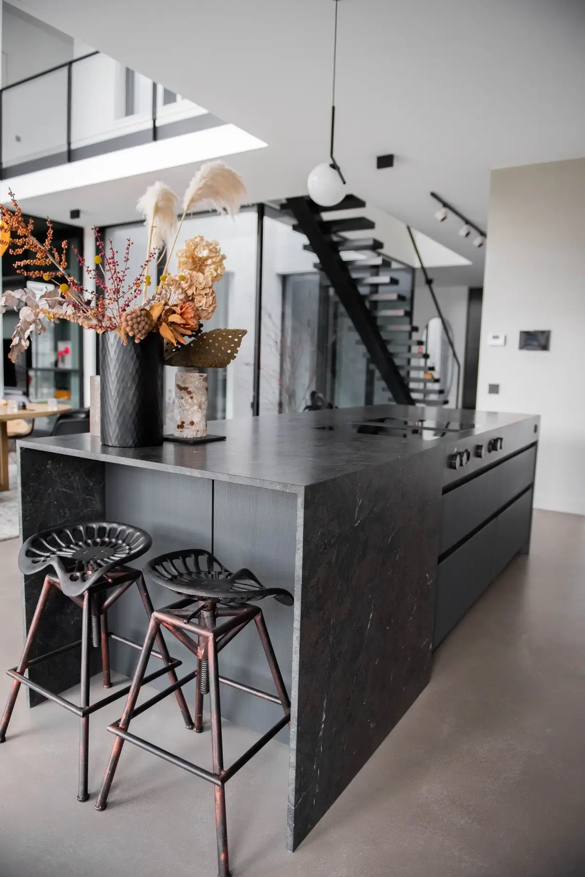 Schwarze Designküche mit Naturstein im Showroom – hochwertige Inszenierung von Material und Raumwirkung